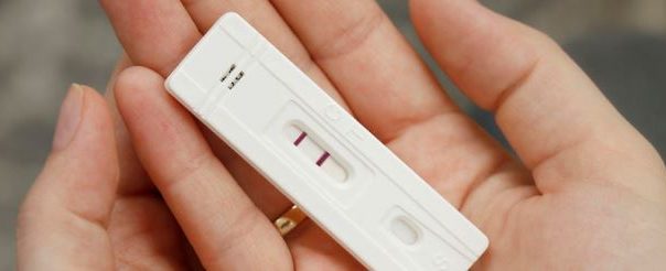 A positive pregnancy test in a woman's hands